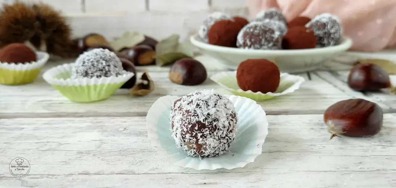 Deliziosi tartufini di castagne, alcuni ricoperti di cocco, altri di cacao, su un tavolo di legno con castagne sparse.