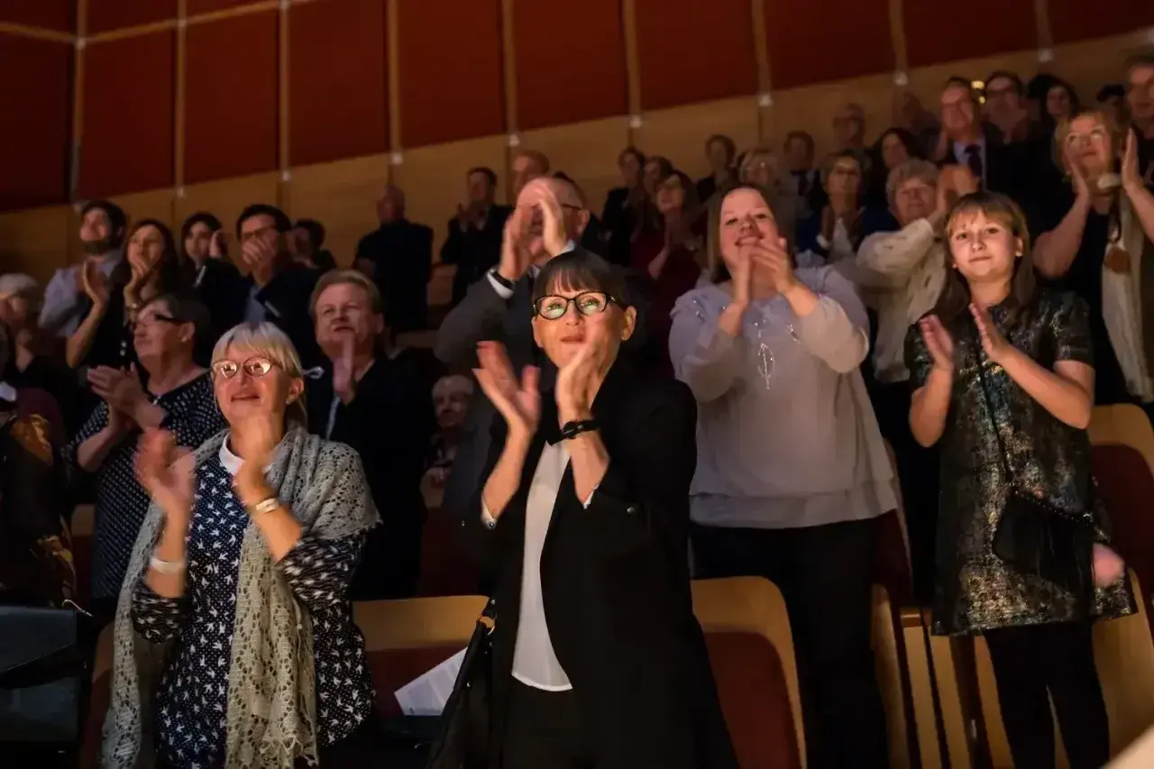 Widownia klaszcze po komedii. Eleganckie stroje, jak się ubrać do teatru na komedię, to pytanie, na które odpowiedzią są stylowe, ale wygodne kreacje.