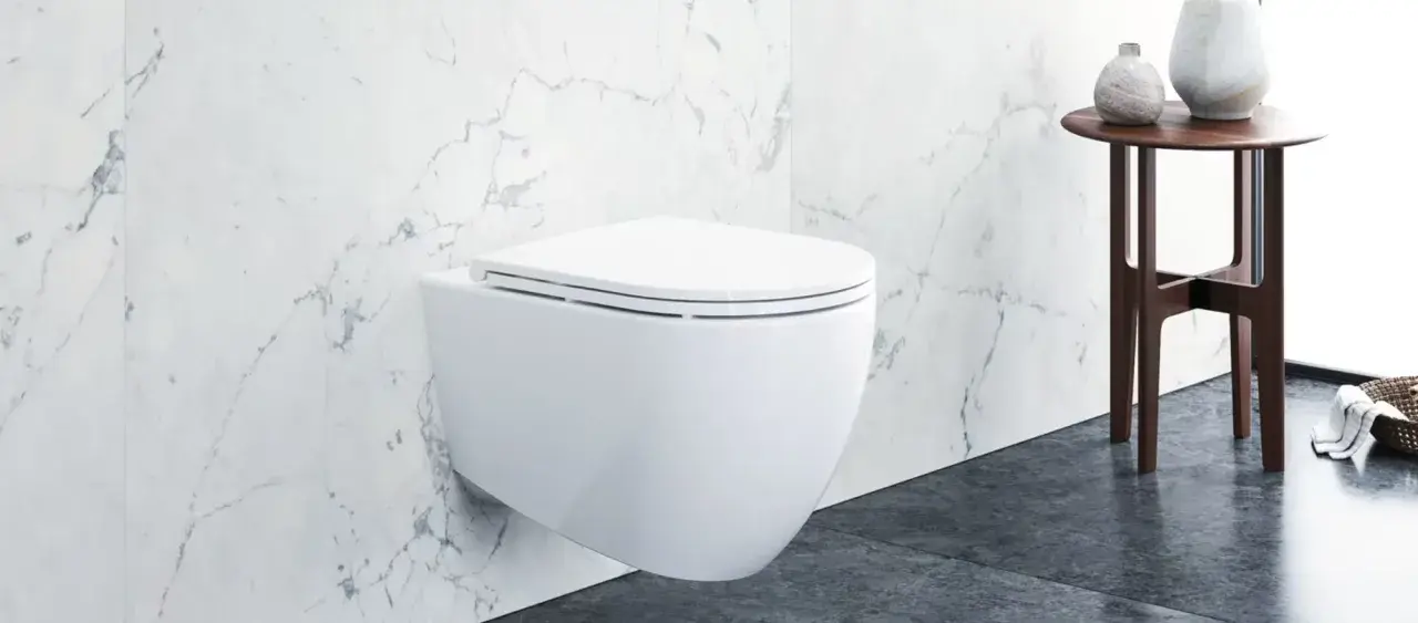 Modernes wandhängendes WC mit Klodeckel montieren. Marmorfliesen und ein Beistelltisch mit Vasen im Hintergrund.