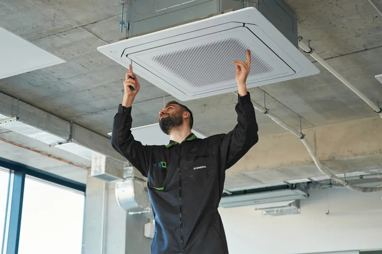 Técnico instalando equipos de climatización en el techo.