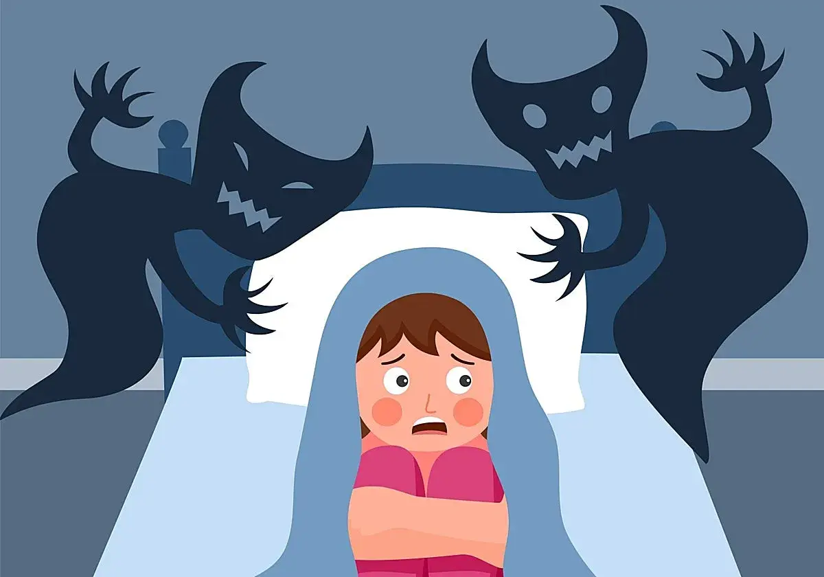 Un niño asustado se esconde bajo las sábanas mientras sombras monstruosas acechan en la oscuridad, evocando terrores nocturnos.
