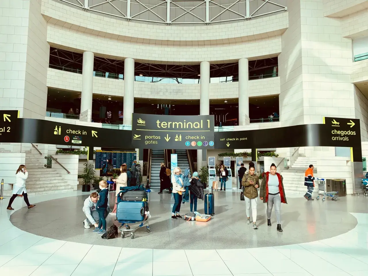 Menschen mit Gepäck im Terminal 1 des Lissabon Flughafens, bereit für die Weiterreise in die Stadt.