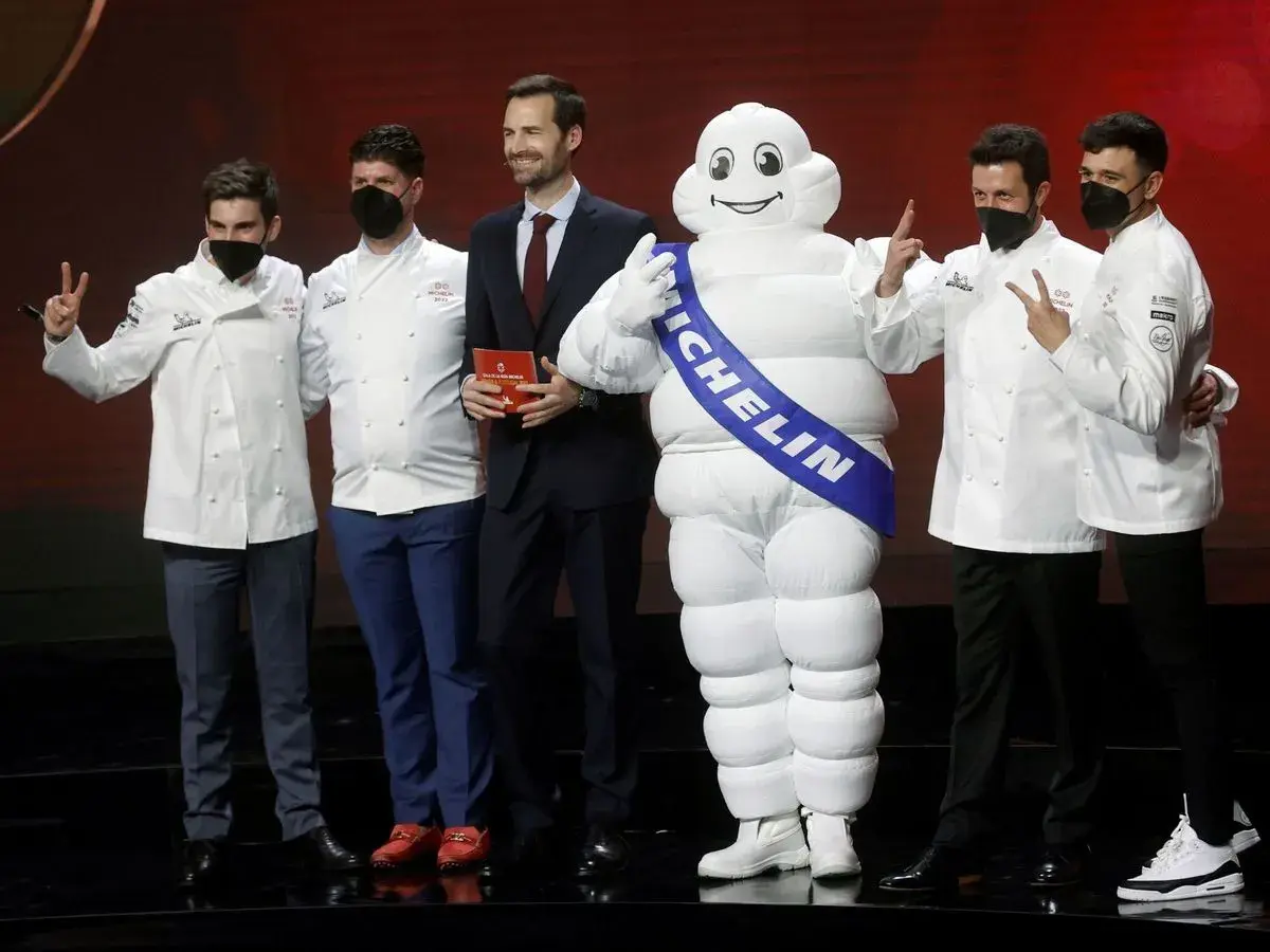 Chefs celebran con el muñeco Michelin, un símbolo de excelencia culinaria y 5 estrellas Michelin.