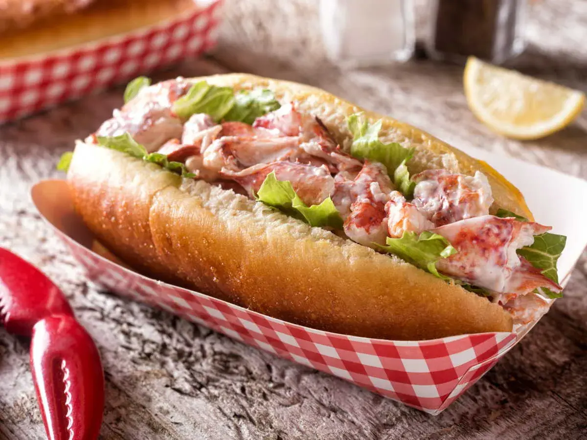 Un généreux hummer sandwich, garni de homard frais et de laitue croquante, servi dans un pain brioché.