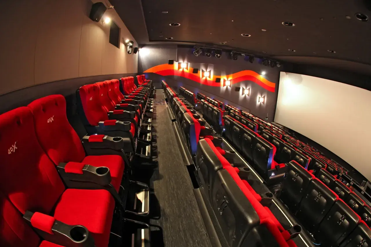 Puste czerwone fotele kinowe z logo 4DX czekają na widzów.