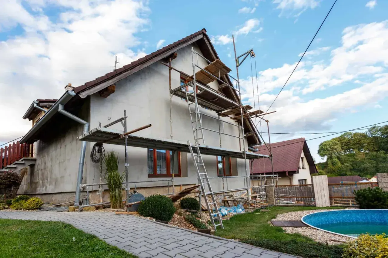 Rusztowanie wokół domu, gotowe do prac remontowych. Dowiedz się, jak zrobić rusztowanie drewniane, by bezpiecznie pracować na wysokości.