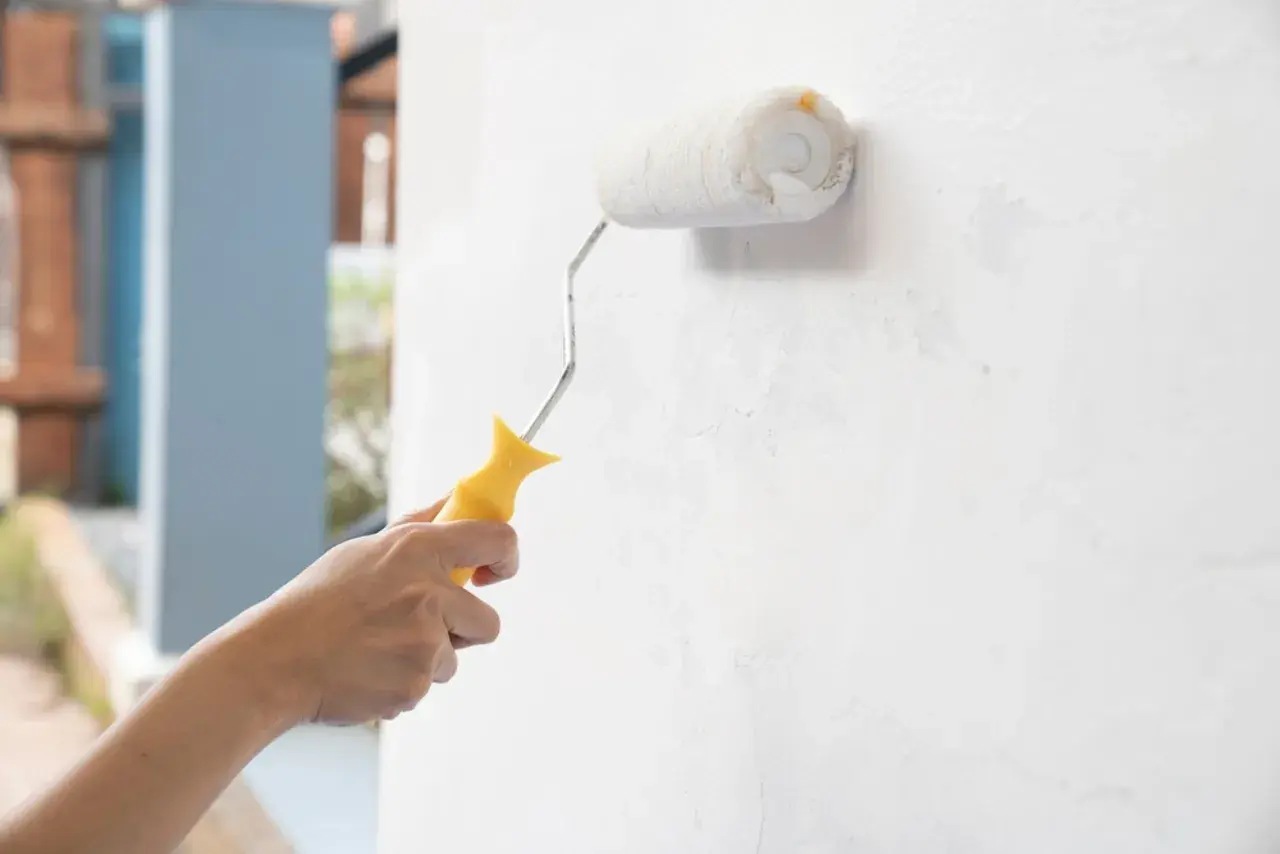 Mano pinta pared interior con rodillo. ¿Qué pasa si pinto con pintura de exterior en interior?
