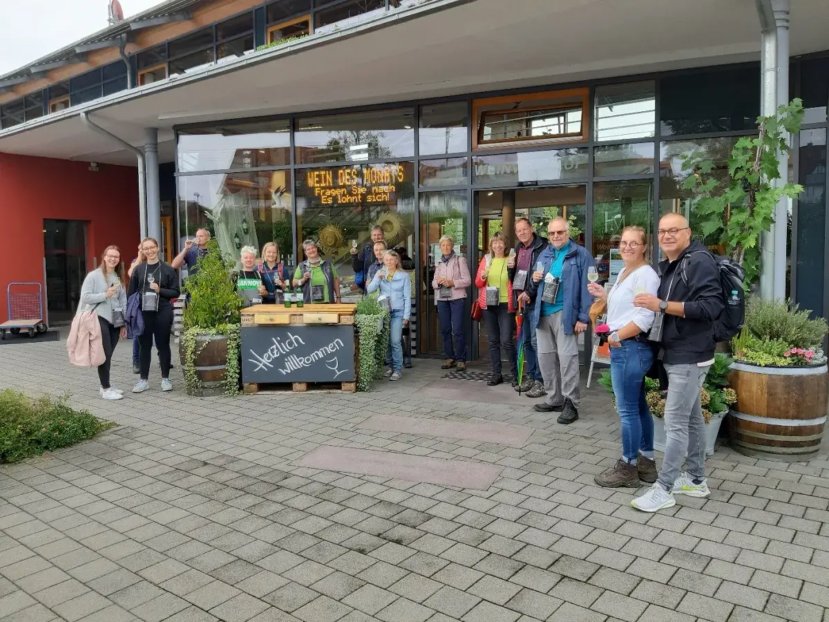Eine Gruppe genießt Wein vor dem Meersburger Winzerverein. Herzlich willkommen!