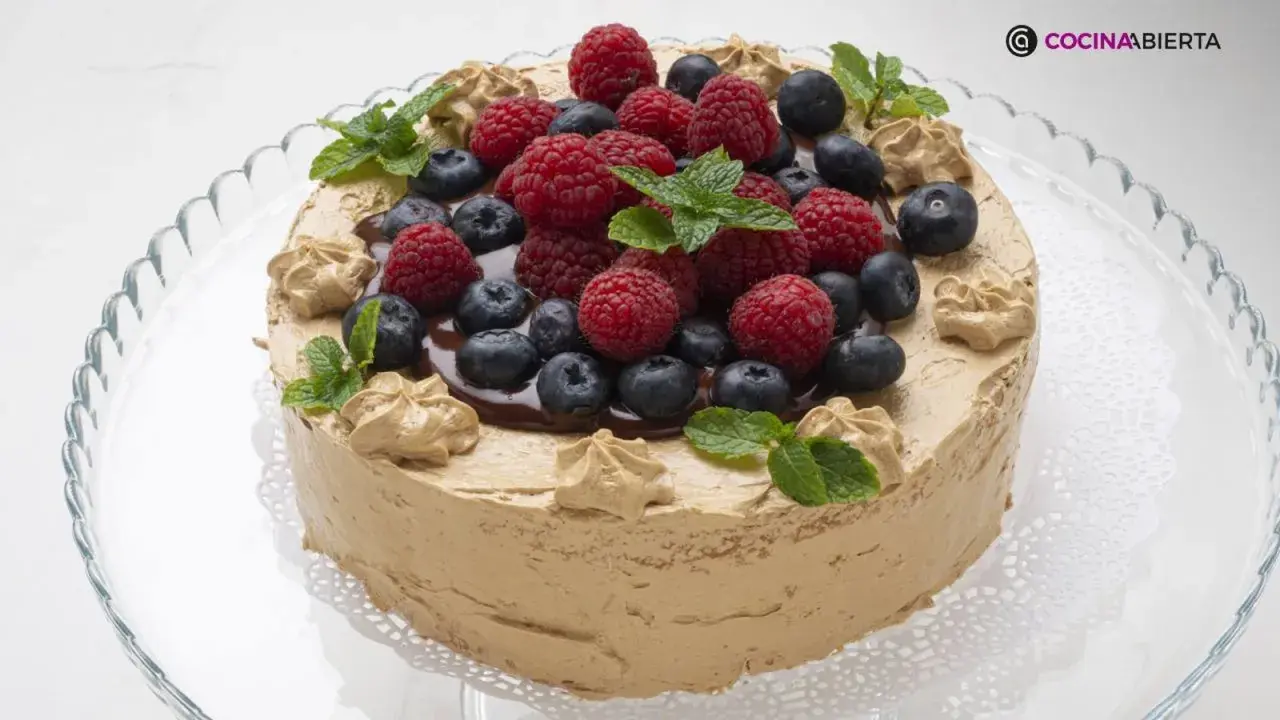 Tarta de moka cubierta de crema de café, decorada con frutos rojos, arándanos y hojas de menta. ¡Una delicia!