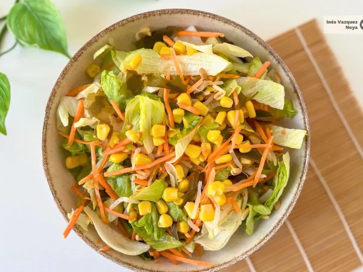 Ensalada china fresca con lechuga, zanahoria rallada, maíz y brotes.
