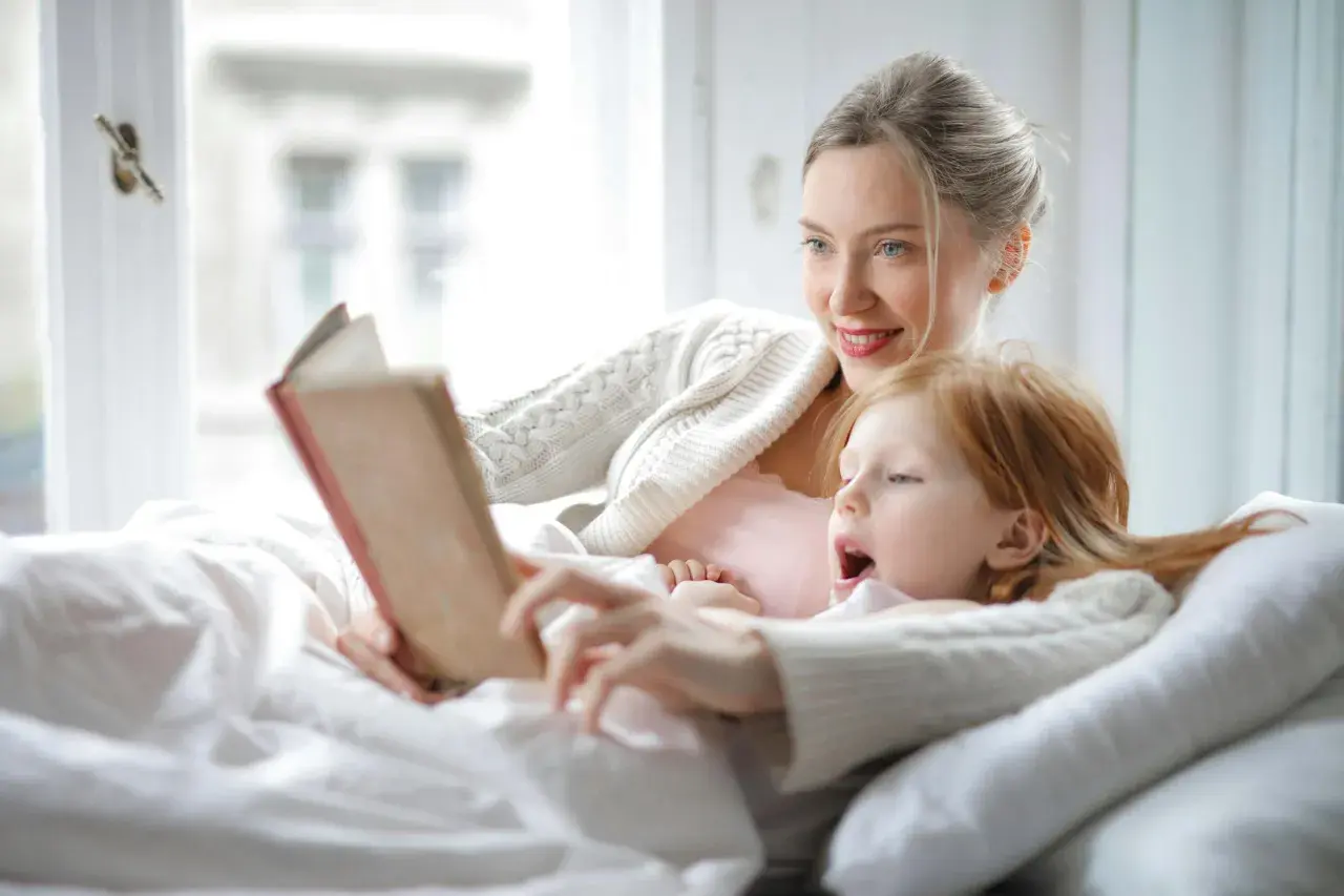 Madre e hija disfrutan de un momento acogedor con lectura en catalán para niños.