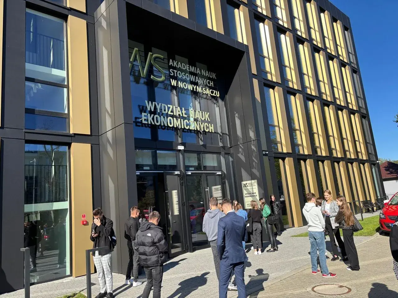 Grupa studentów przed Akademią Nauk Stosowanych w Nowym Sączu. Wydział Nauk Ekonomicznych, kierunkowy 18 Polska.