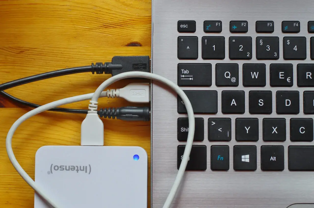 Externe Festplatte wird als USB-Laufwerk erkannt. Kabel verbinden die Festplatte mit dem Laptop.