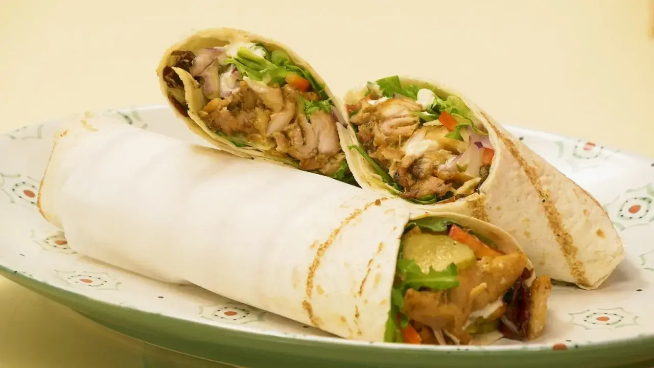 Pyszny domowy kebab w tortilli z soczystym mięsem, świeżymi warzywami i kremowym sosem. Idealny na szybki posiłek.