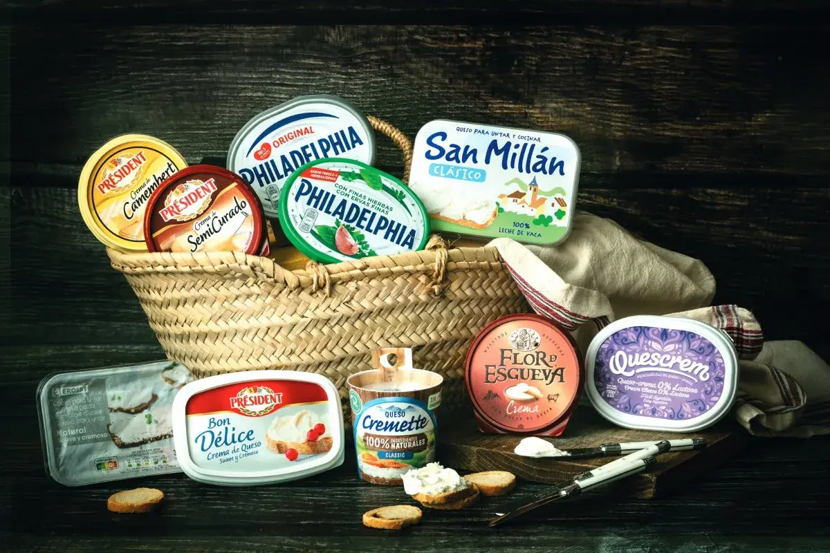 Variedad de quesos crema en cestas y recipientes, incluyendo marcas como Philadelphia y Président. Ideal para untar y disfrutar.