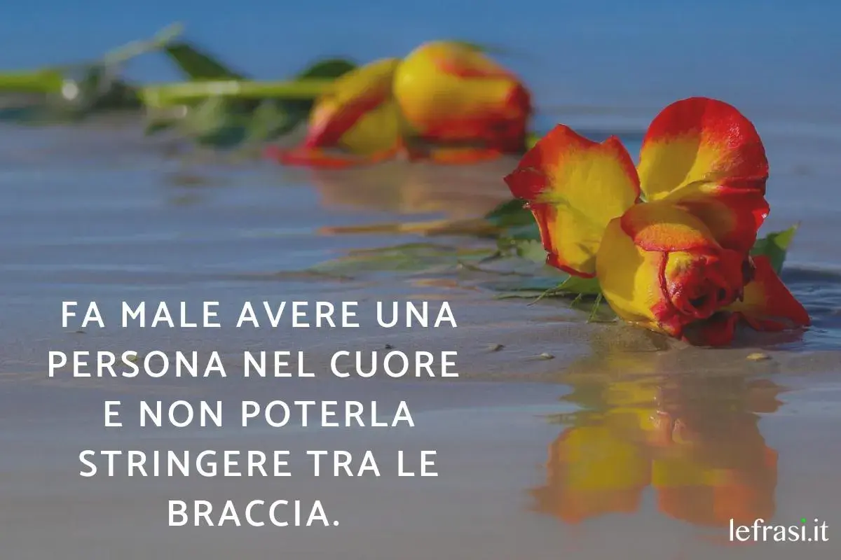 Rose bagnate sulla sabbia, un'immagine che evoca il dolore di come dimenticare un amore non corrisposto, quando il cuore desidera un abbraccio negato.