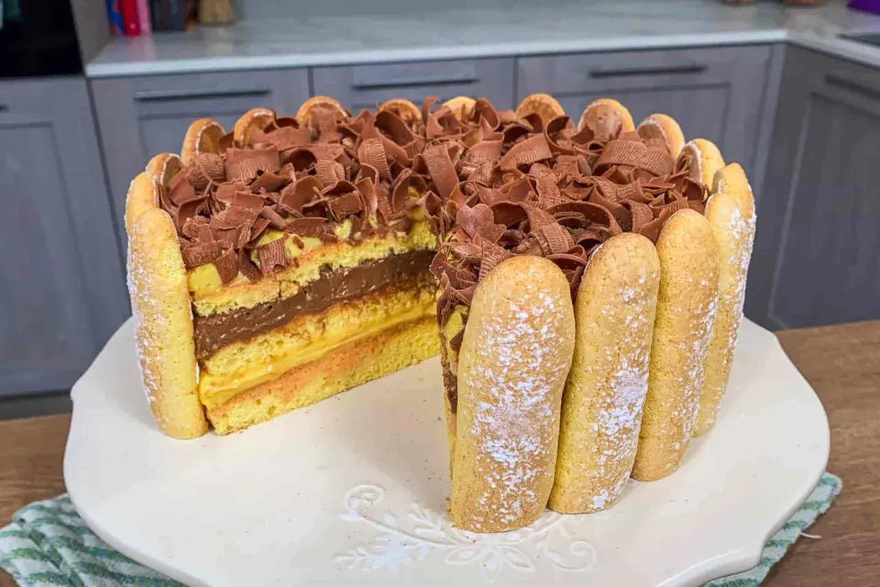 Una deliziosa zuppa inglese ricetta facile, con strati di pan di Spagna, crema pasticcera e cioccolato, decorata con savoiardi e riccioli di cioccolato.