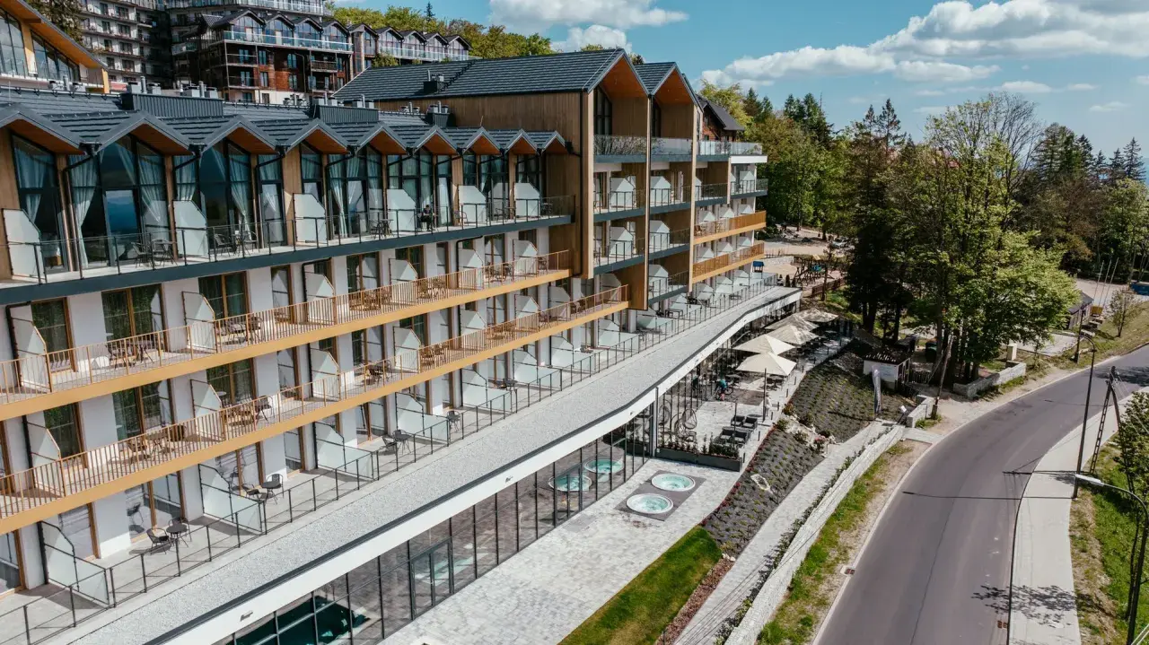 Nowoczesny hotel ze złotymi balkonami i tarasami, z widokiem na las. Złoty horyzont resort szklarska poręba zaprasza na relaks.