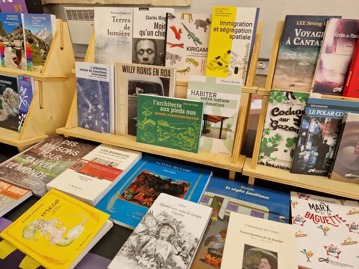 Exposition de livres, dont des titres de **les plus grandes maisons d'édition françaises**, sur des étagères en bois.