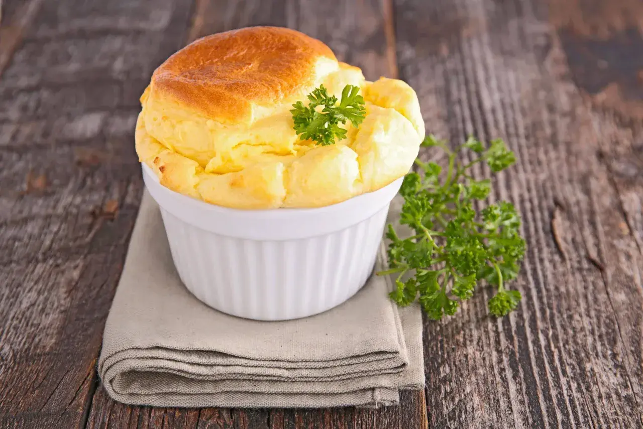 Un soufflé salé doré et aérien, garni de persil frais, parfait pour une recette de soufflé salé facile.