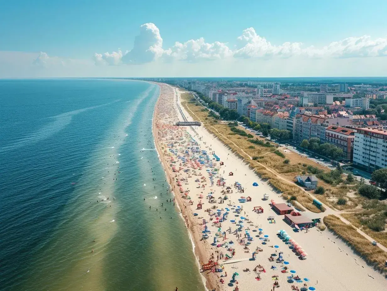 Słoneczna plaza Stogi tętni życiem. Tłumy plażowiczów, kolorowe parasole i błękitne morze tworzą wakacyjny obraz.