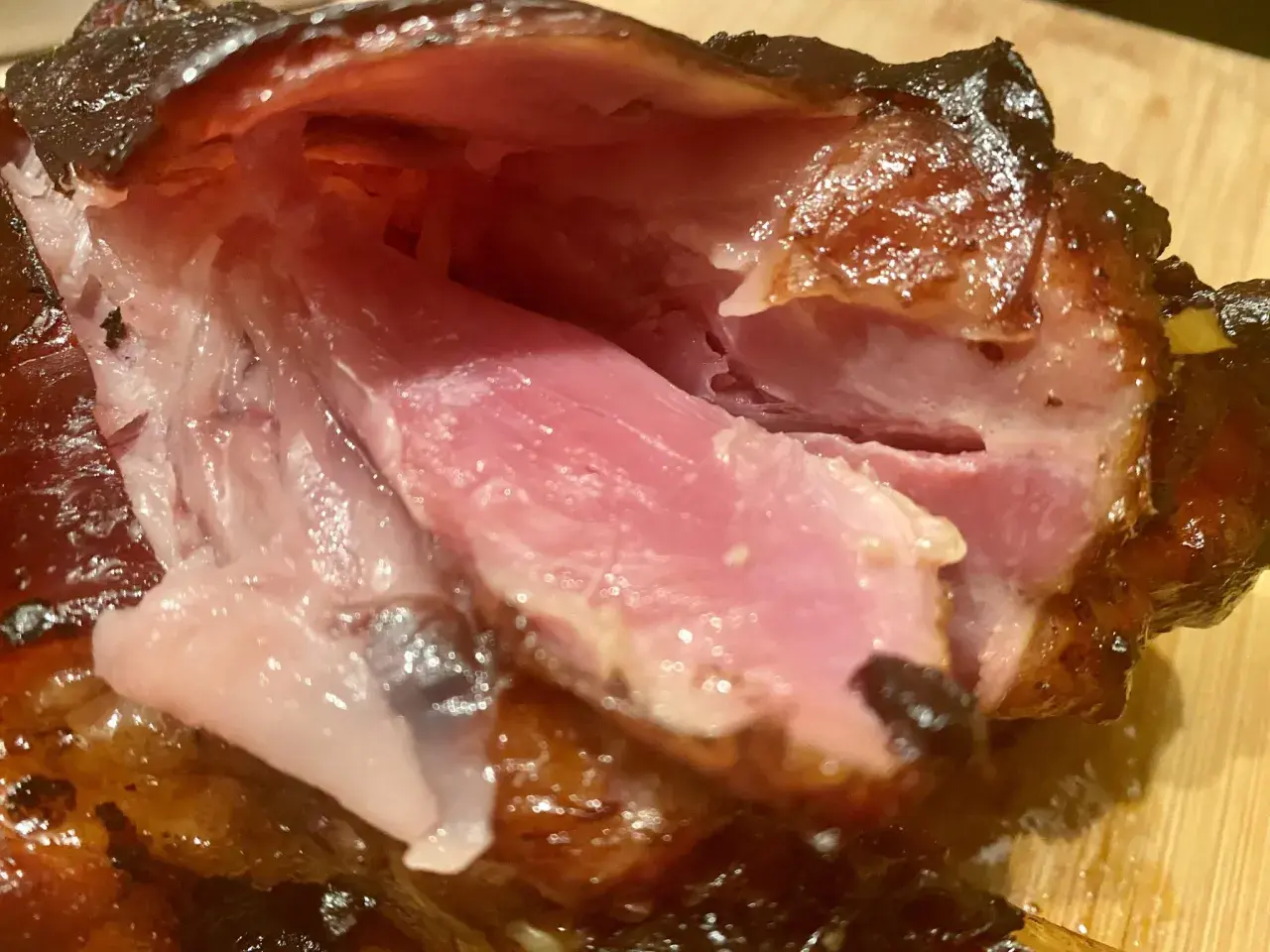 Gros plan sur des kakos de porc juteux et caramélisés, la chair rose tendre contrastant avec la peau croustillante.