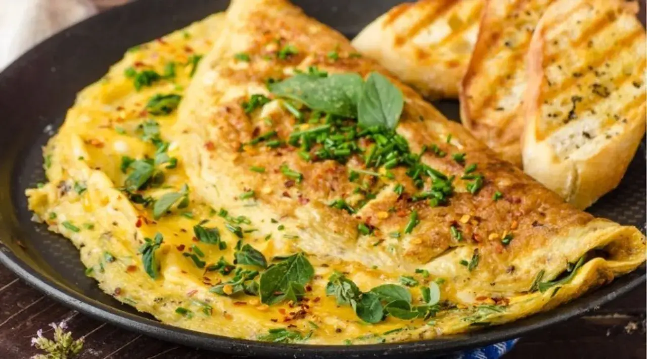 Puszysty omlet bez mąki, posypany szczypiorkiem i płatkami chili, podany z grzankami czosnkowymi. Idealne śniadanie.