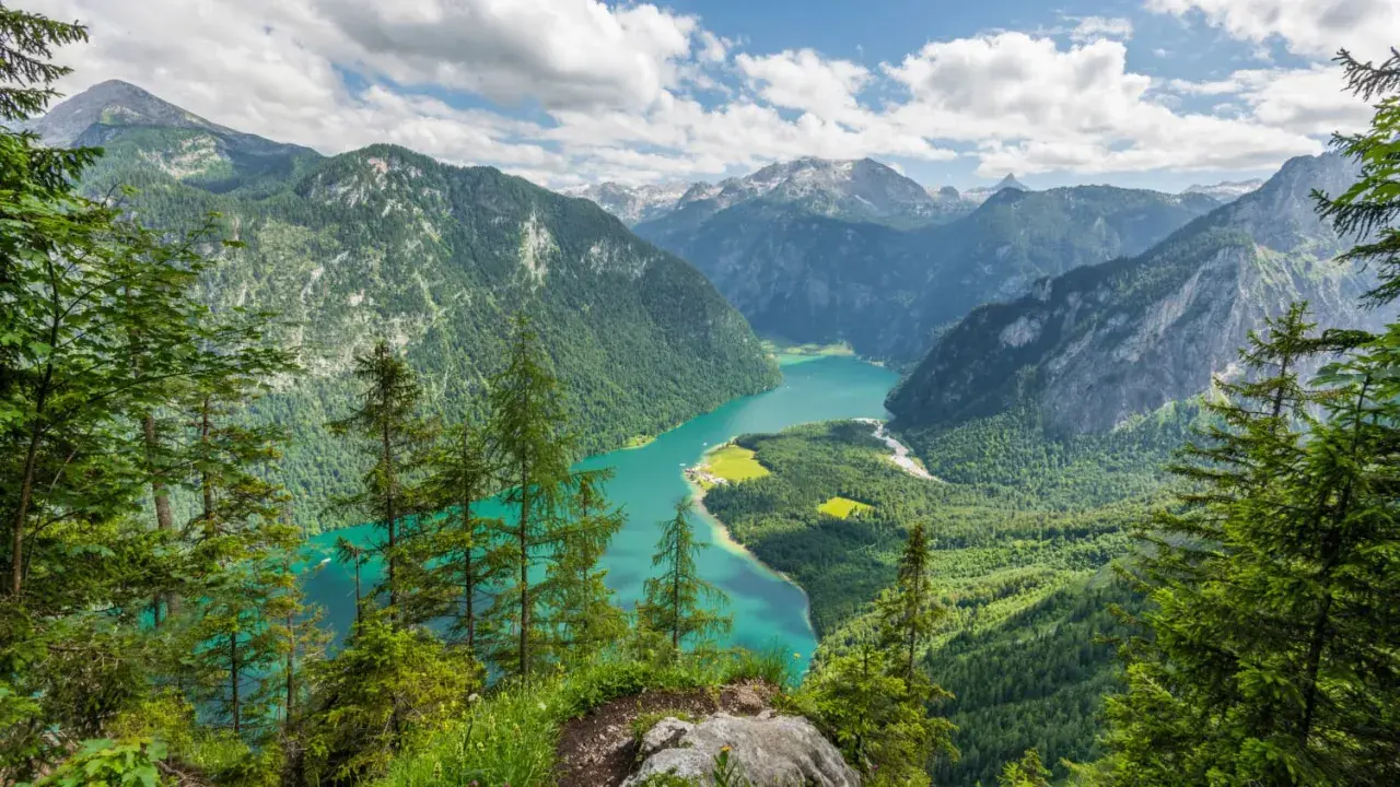 Türkisblaue Bergseenlandschaft mit bewaldeten Hängen und Gipfeln. Ein atemberaubender Ausblick in einem wilden Nationalpark.