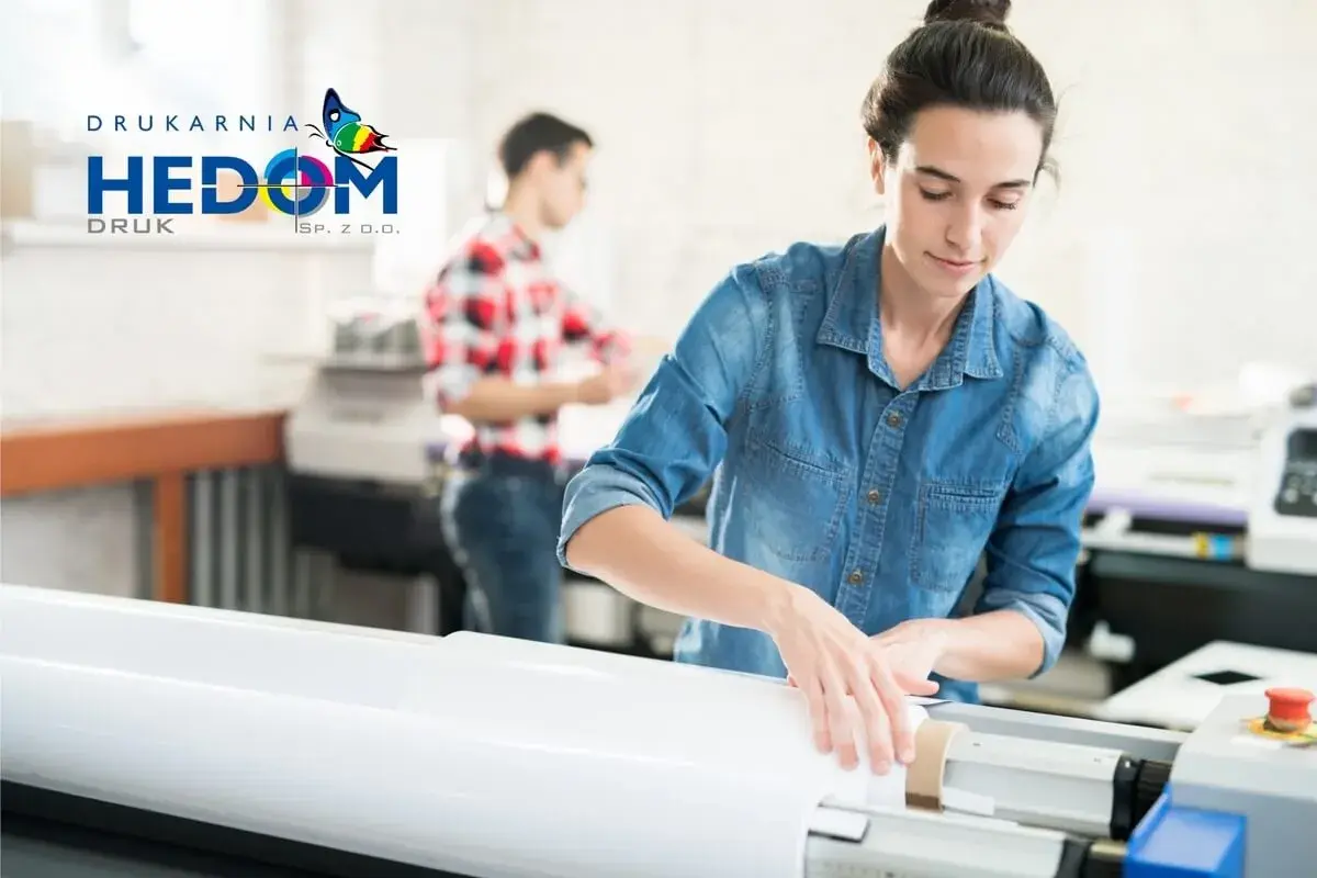 Kobieta w drukarni przygotowuje materiał do druku. To pokazuje, jak różnica między wydaniem papierowym a wersją "print on demand" jest realizowana w praktyce.
