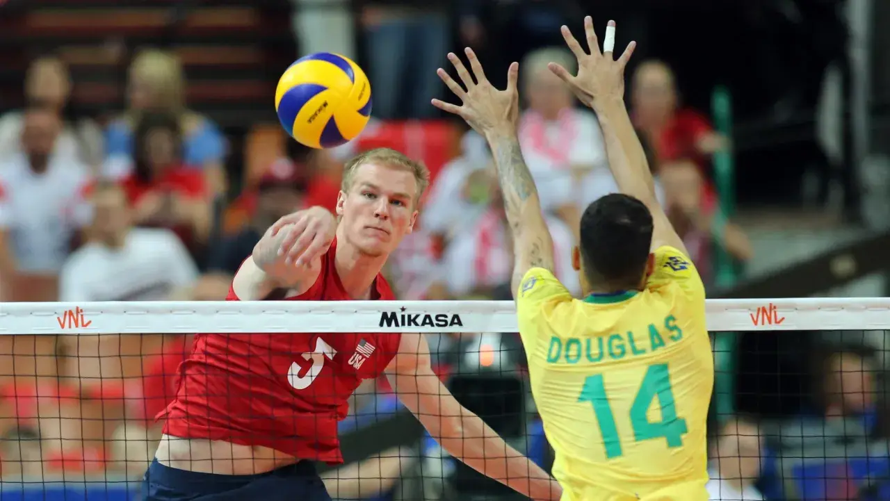 Kyle Russell z USA atakuje piłkę do siatkówki, blokowany przez Douglasa z Brazylii.