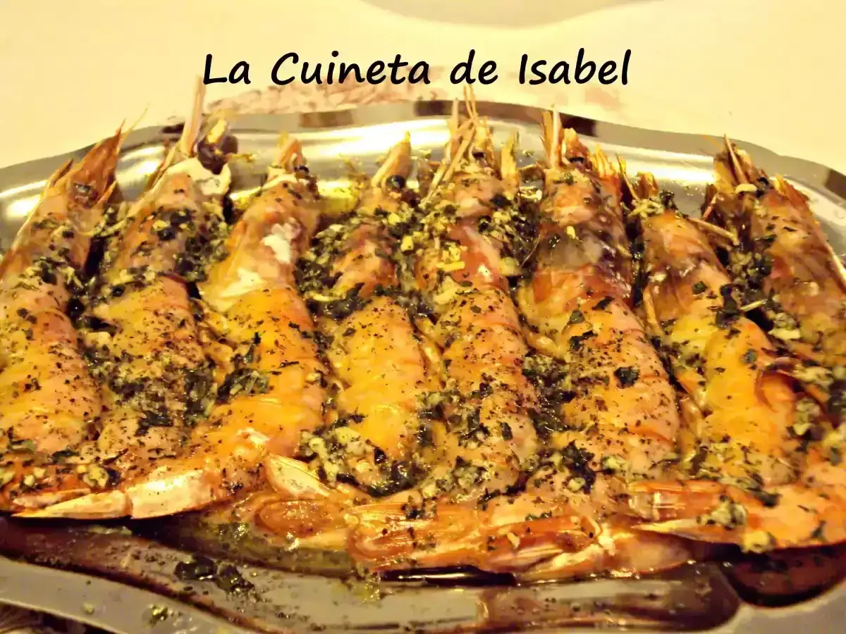 Langostinos al horno, jugosos y dorados, con hierbas y ajo, servidos en una bandeja metálica. ¡Un manjar de La Cuineta de Isabel!