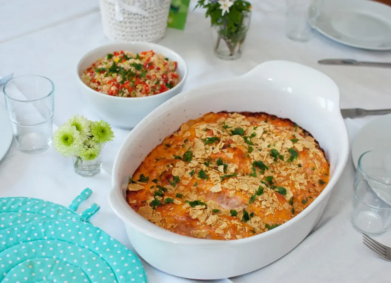 En gratinerad laxrätt med krispigt topping, perfekt för ett fredagsmys recept. Serveras med en fräsch couscoussallad.
