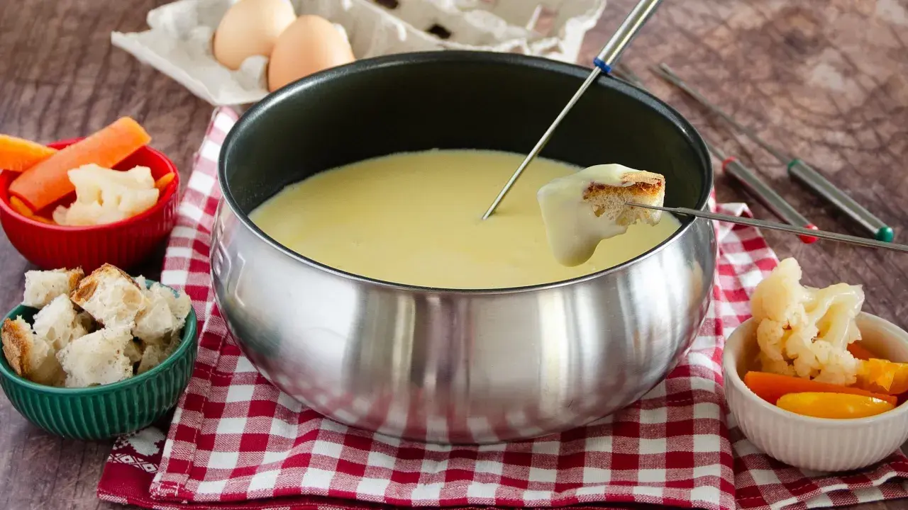 Una calda fonduta Valle d'Aosta, con pane croccante e verdure fresche, pronta per essere gustata.