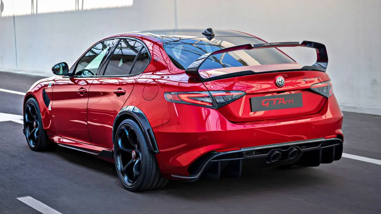 Czerwone Alfa Romeo Giulia GTAm z masywnym spoilerem i dyfuzorem, gotowe do wyścigu.