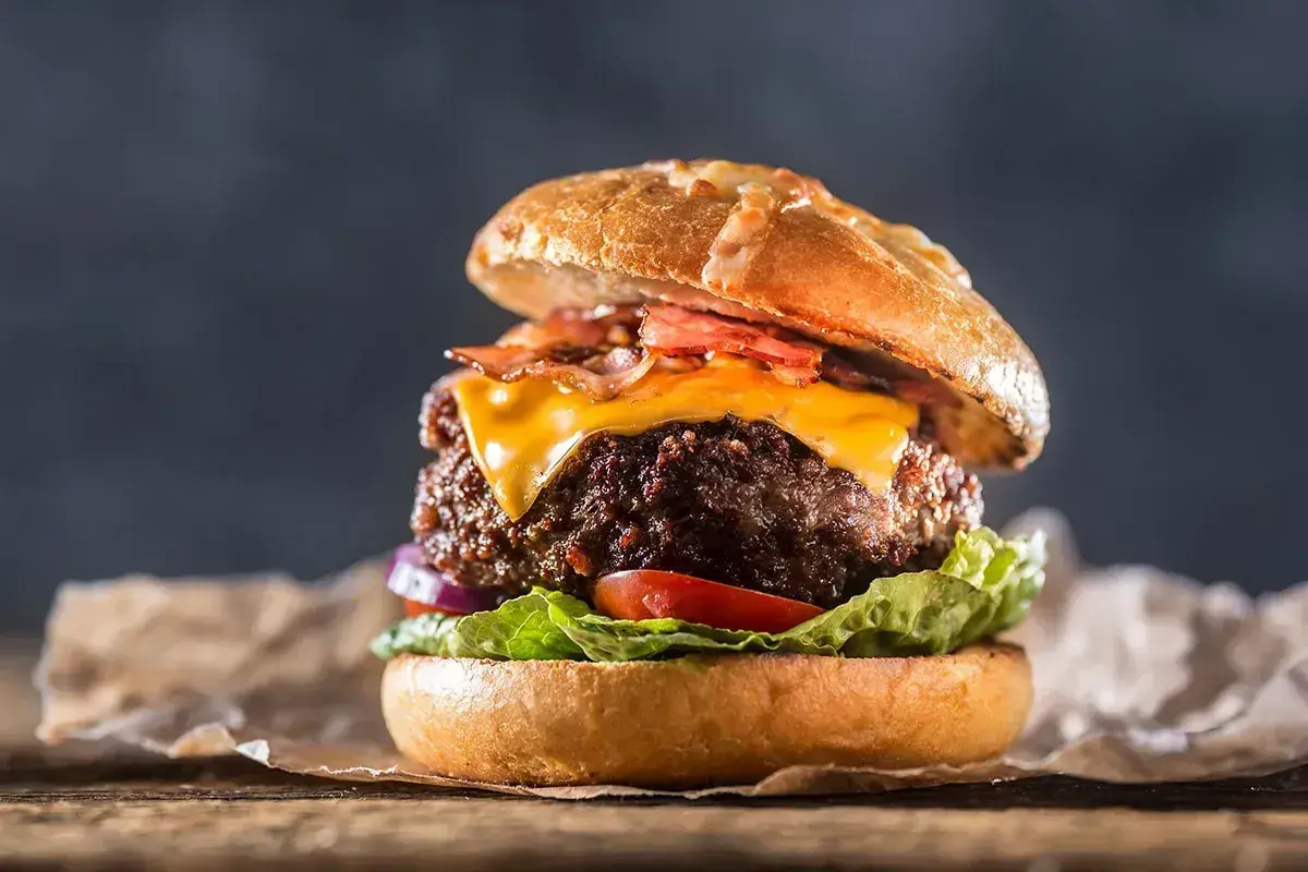En saftig hamburgare med ost och bacon, perfekt för att grilla hamburgare en sommarkväll.