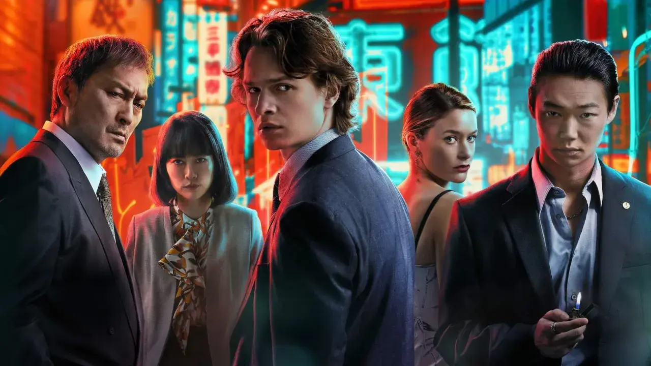 Fem personer poserar framför neonupplysta skyltar i Tokyo. En ung man i kostym blickar intensivt mot kameran, en scen som fångar essensen av "Tokyo Vice".