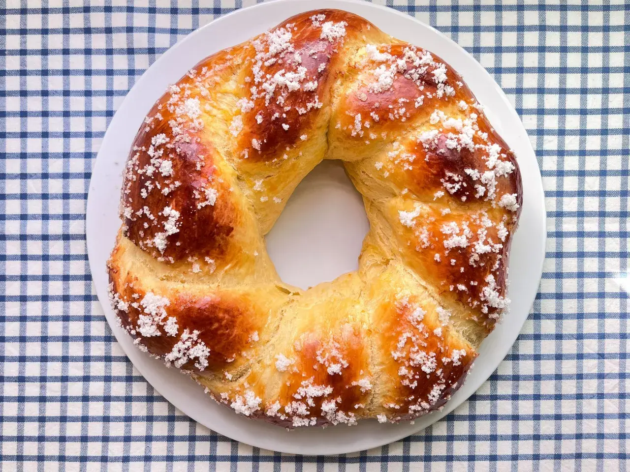 Rosca de Pascua dorada y brillante, espolvoreada con azúcar, lista para compartir en familia.
