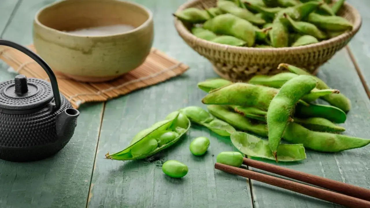 Zielone strąki edamame, miseczka z napojem i czajniczek. Czy wiesz, edamame co to?