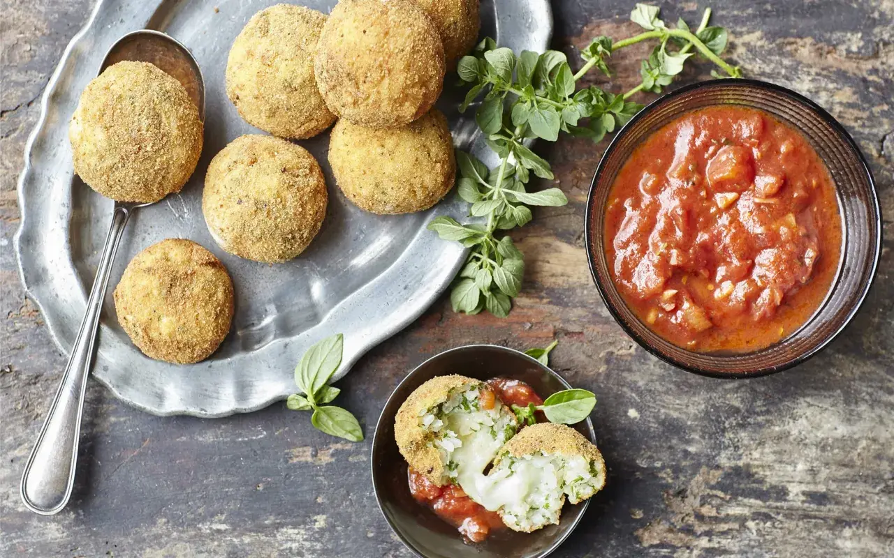 Arancini dorés et croustillants servis avec une sauce tomate savoureuse, parfaits pour tremper.
