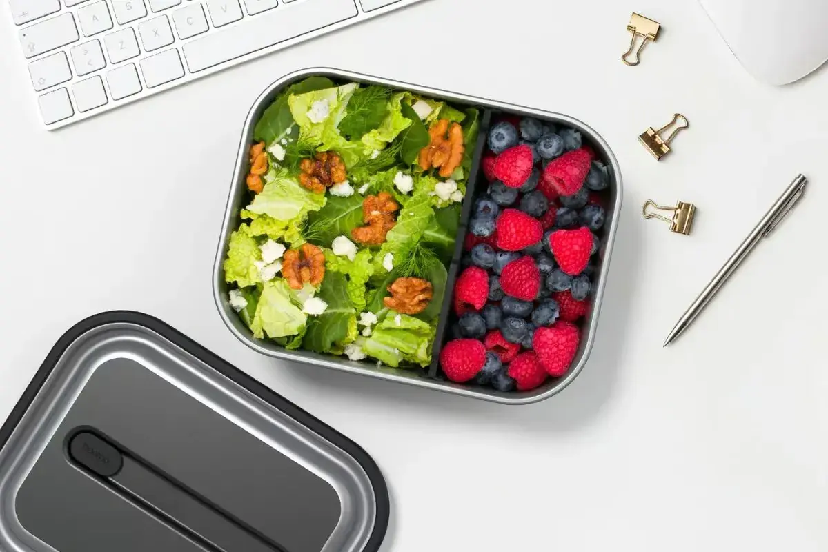 A healthy lunch bento box with a fresh salad and berries, perfect for a desk lunch, not a curry bento box.