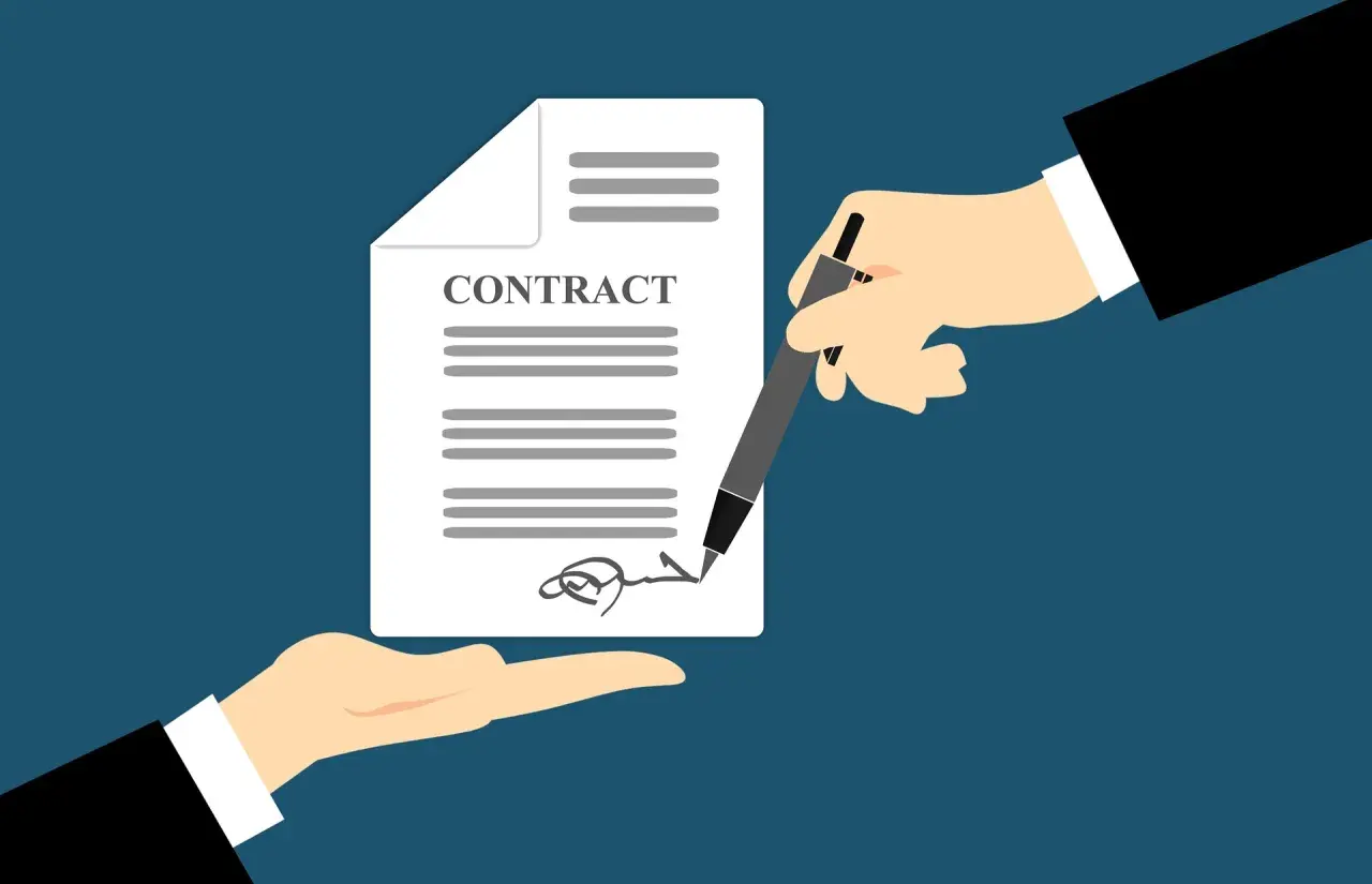 Manos firman un contrato de trabajo. Es obligatorio firmar un contrato de trabajo para formalizar el empleo.