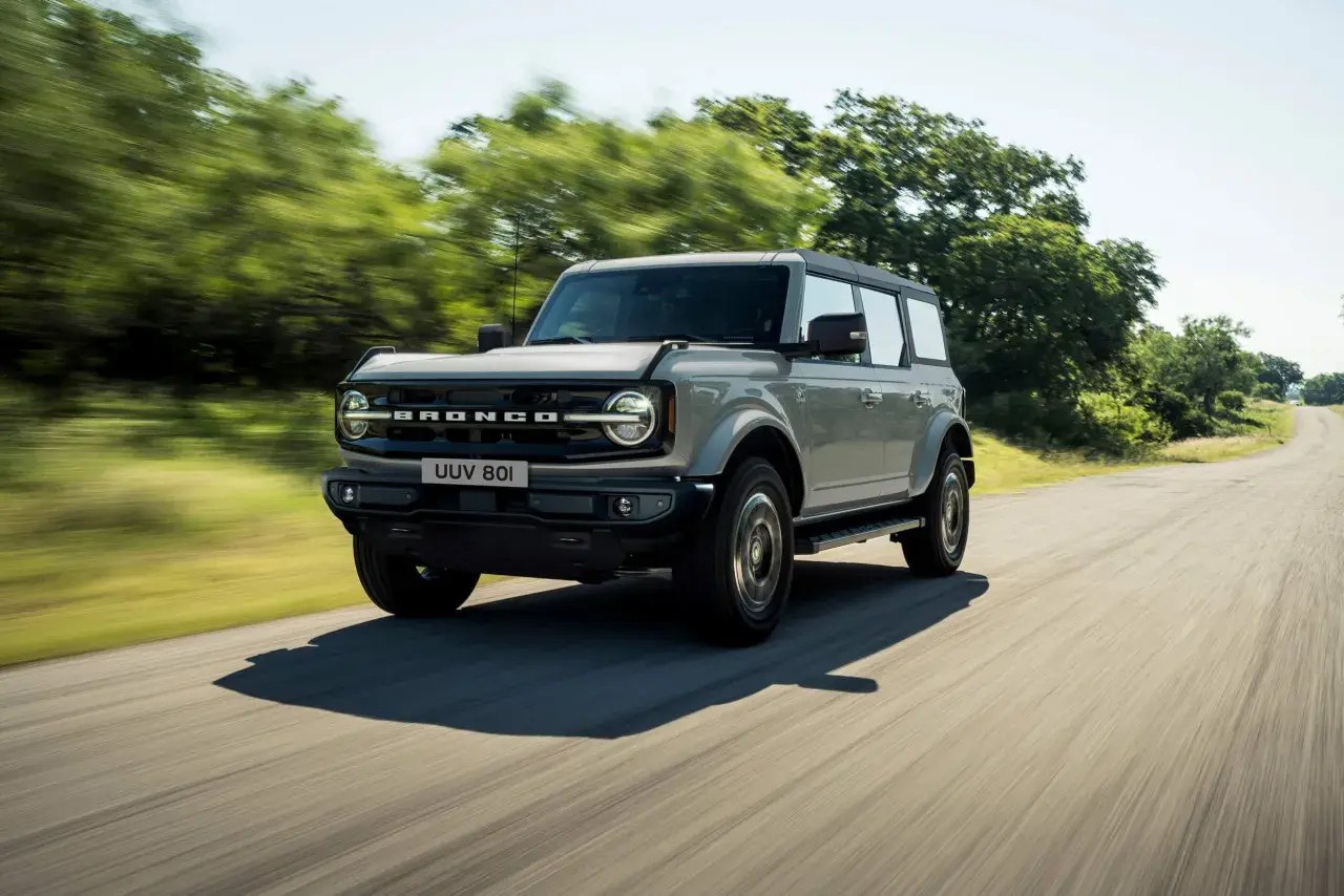 Grå Ford Bronco kör på en landsväg. Kolla in ford bronco pris för ditt nästa äventyr.