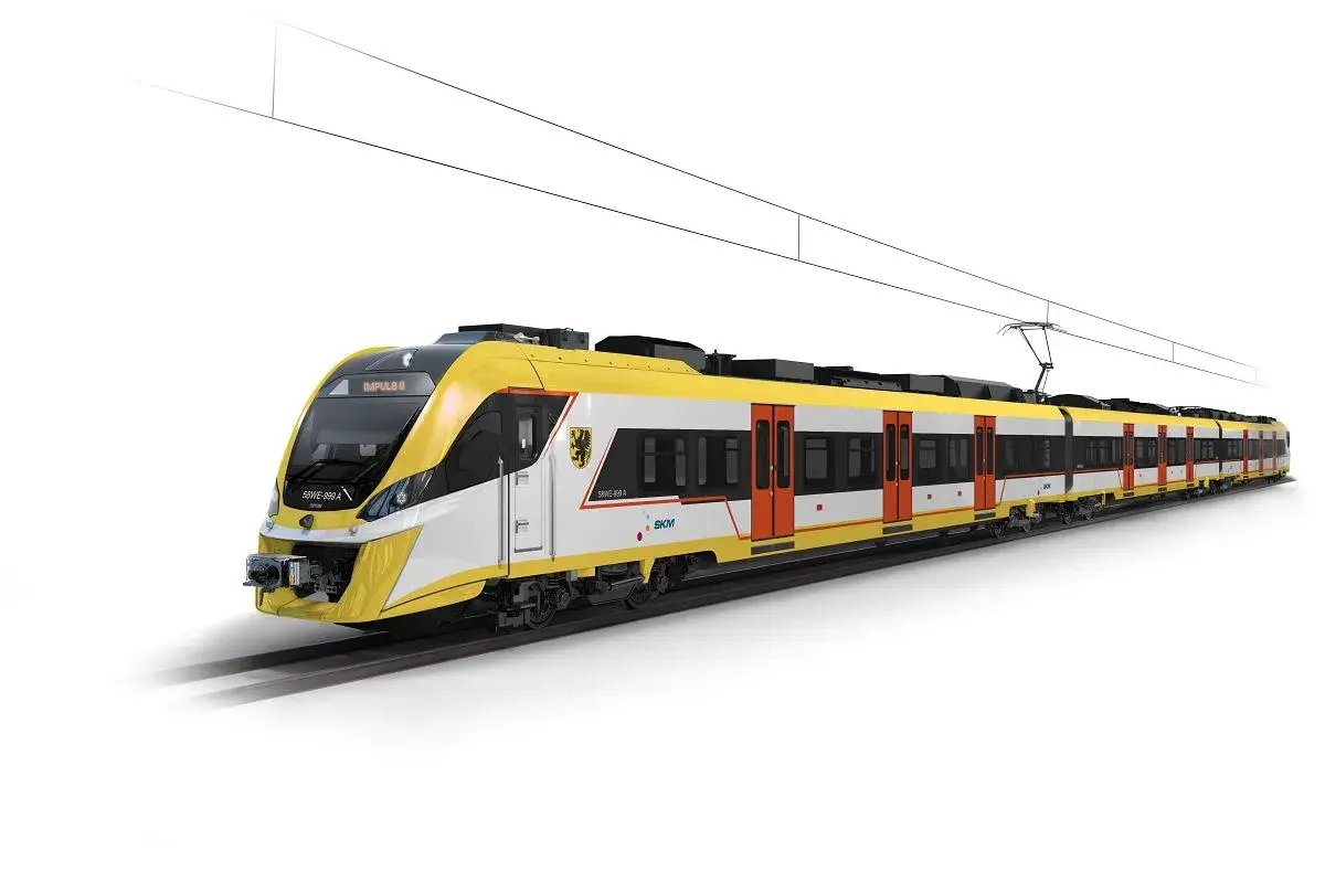 Nowoczesny, żółto-biały pociąg elektryczny Impuls II, jeden z wielu rodzajów pociągów, jedzie po torach pod siecią trakcyjną.