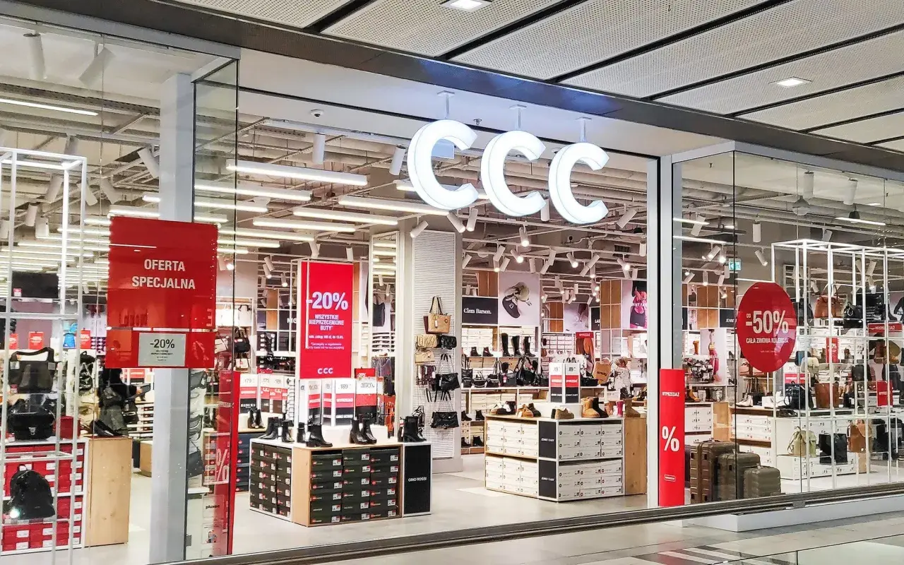 CCC - promocje w sklepach stacjonarnych. W witrynie sklepu CCC widoczne są wyprzedaże -20% i -50% na obuwie i torebki.