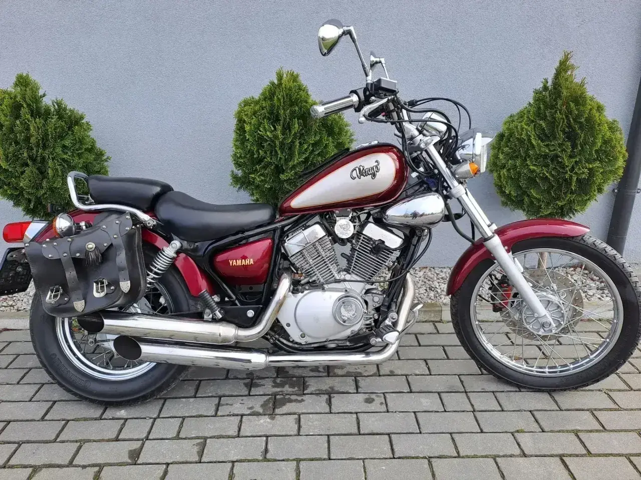 Klasyczny motocykl Yamaha Virago 125, z sakwami i ozdobnym malowaniem. Idealny do miasta, jego wymiary są kompaktowe.