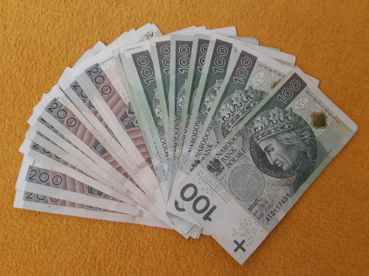 Darowizna spadku na rzecz siostry: stos banknotów 100 i 200 zł ułożony wachlarzem.