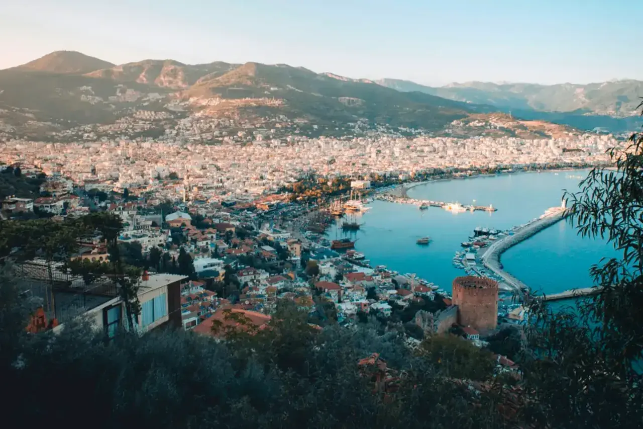 Vy över Alanya med hamn, berg och stad. Perfekt för Alanya aktiviteter som båtturer och utforskning av historiska platser.