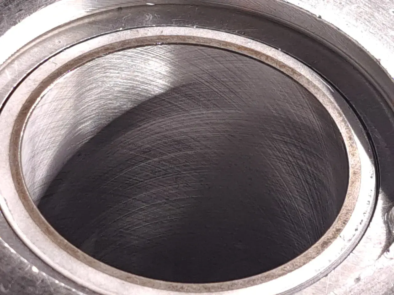 Metalowy cylinder z widocznymi śladami obróbki. Wnętrze, czyli big bore, jest ciemne i lekko błyszczące.