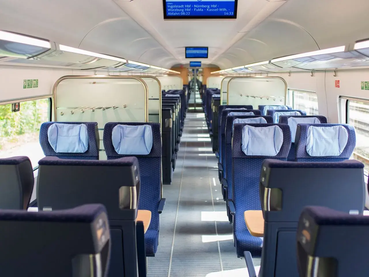 Leere Sitze in einem modernen Zugabteil. Die blauen Polster mit hellblauen Kopfkissen laden zur entspannten train ride ein.