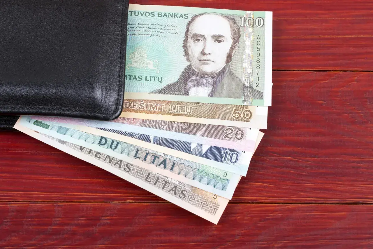 Czarny portfel z litewskimi banknotami. Widać banknot 100 litów z portretem mężczyzny, a pod nim mniejsze nominały: 50, 20, 10, 5 litów. Litwa waluta.